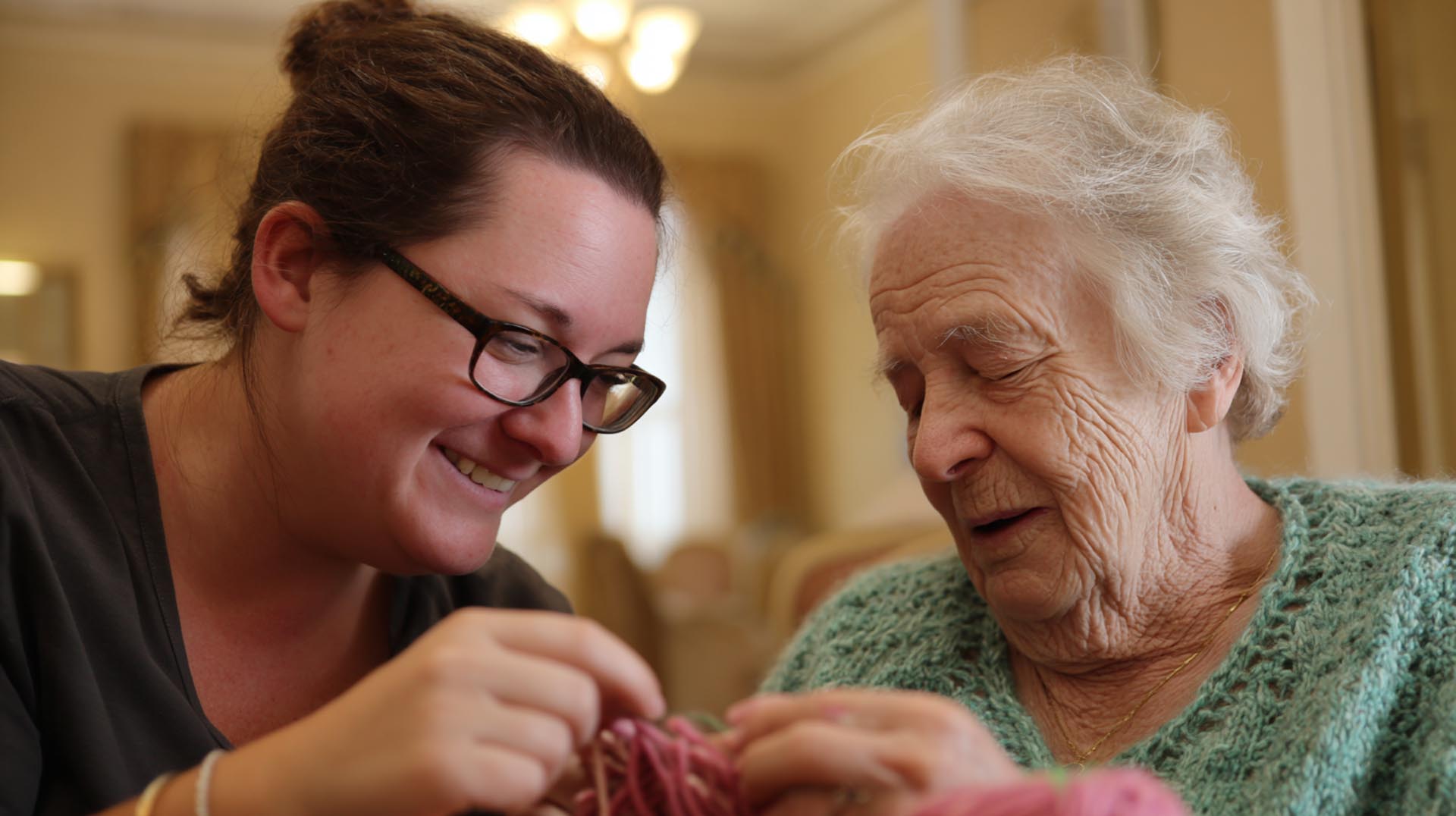 A nurse provides family and caregiver support by reviewing a resource brochure with a patient's adult daughter, a key topic in this comprehensive Alzheimer's CE Nursing course.
