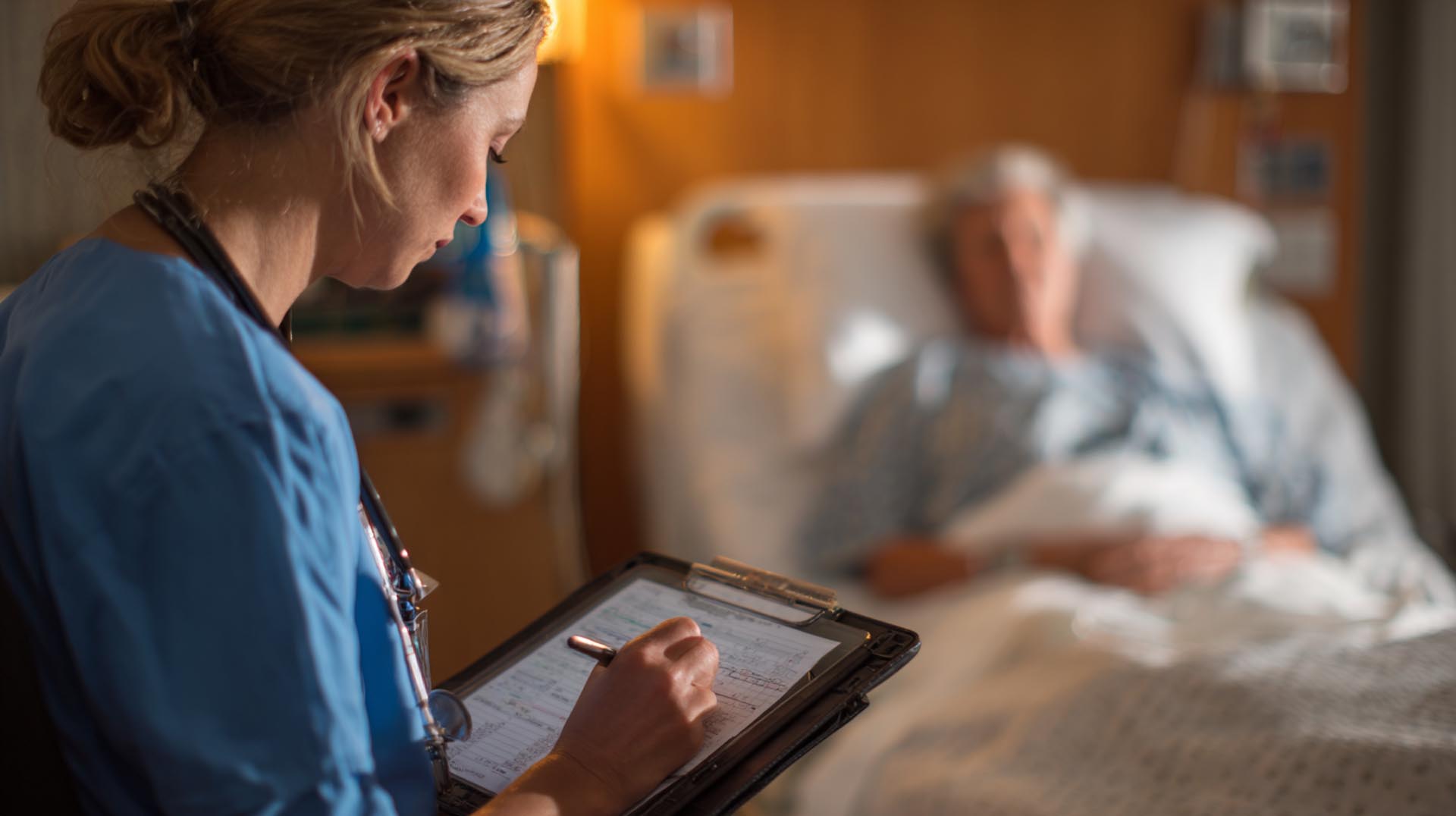 Nurse reviewing patient documentation on a tablet in a modern hospital setting – accurate nursing documentation to avoid litigation.